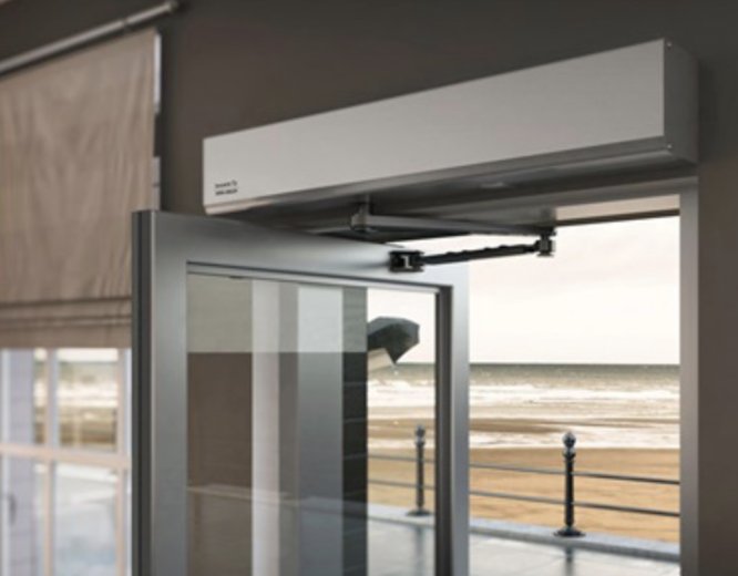 Automatic swing door operator installed above a glass entrance